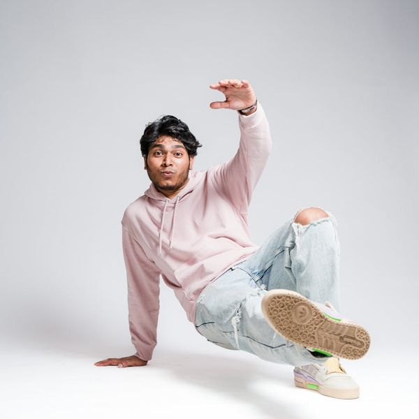 Man in a balanced pose showing focus and stability in a modern studio.